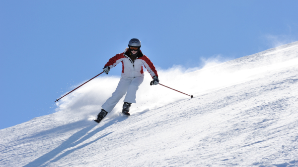 Skidåkare som njuter av nysnö i en pist i Zillertal, Österrike, under en skidresa till Alperna.